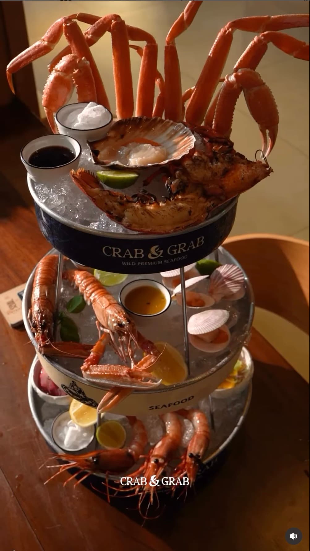 Crab&Grab Signature Seafood Tower — snow crab, lobster, scallops, prawns, and dipping sauces on a three-tier display